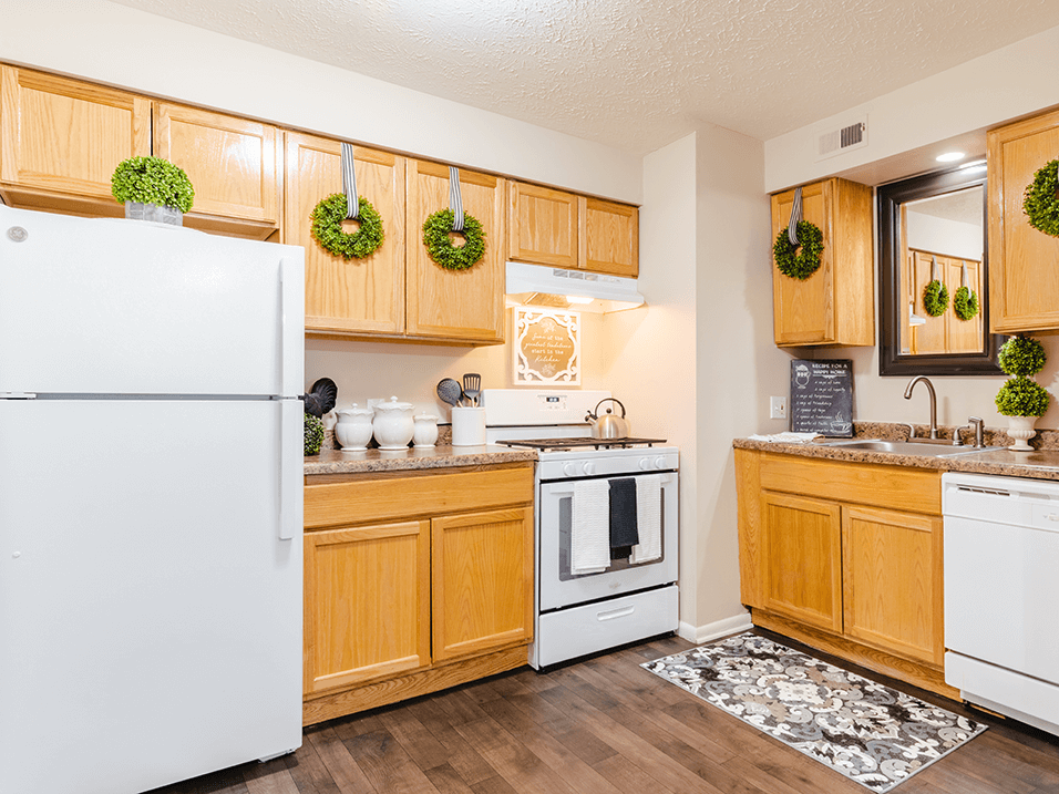 a kitchen with white appliances and wooden cabinets
