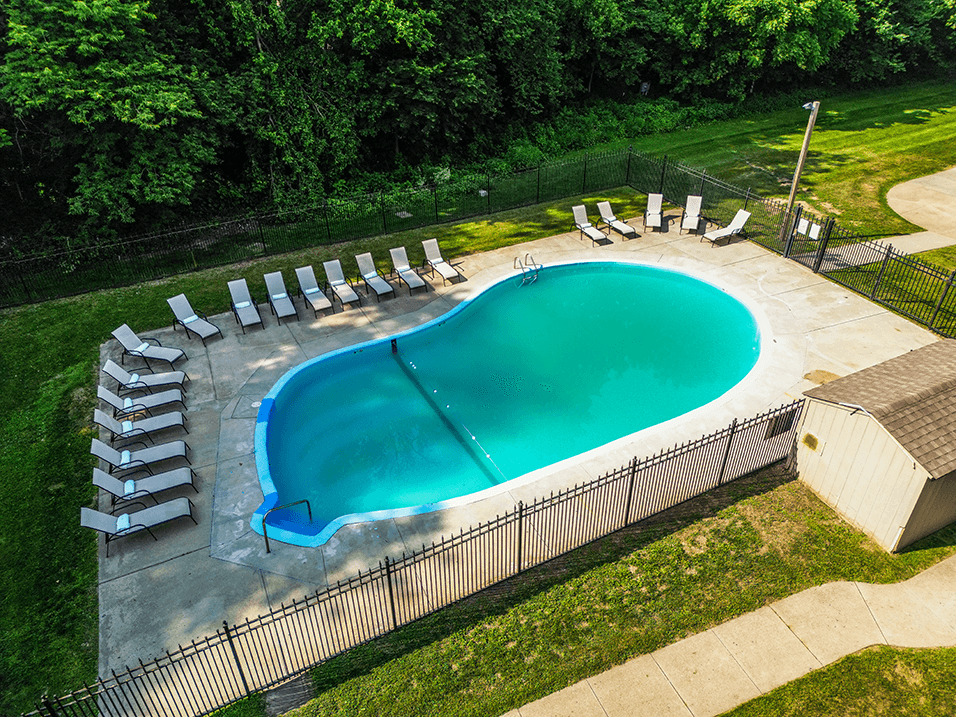 an aerial view of a resort style pool with lounge chairs and a hot tub