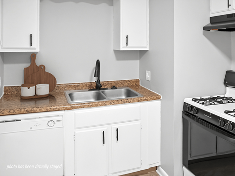 A kitchen with white cabinets and a black stove top.