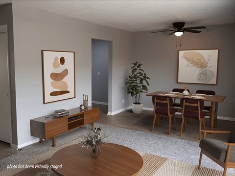 A living room with a brown coffee table and a grey rug.