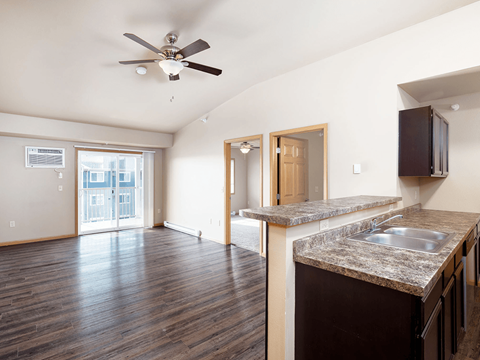 A kitchen with a fan on the ceiling and a counter top.