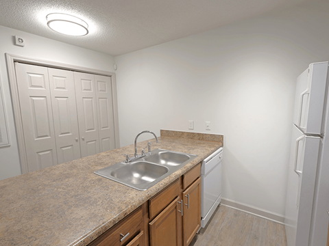 A kitchen with a sink and a refrigerator.
