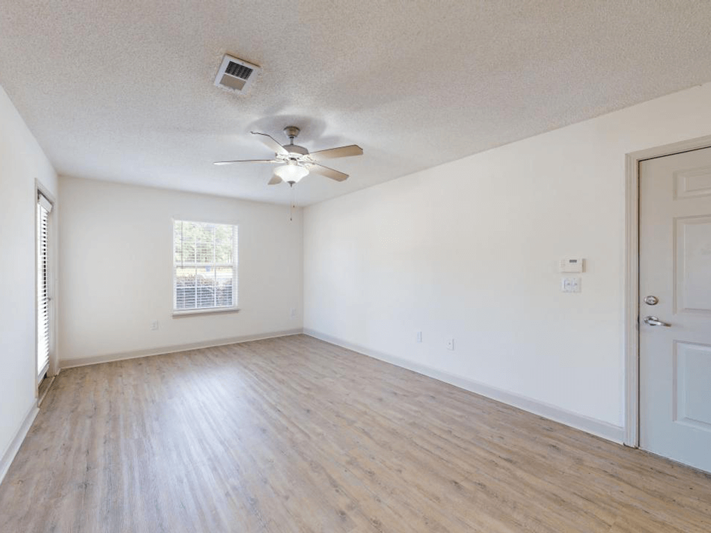an empty Living room with white walls and a ceiling fan