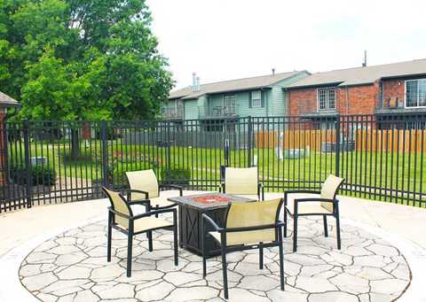 a firepit area with chairs at apartment complex