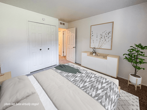 A bedroom with a large bed and a plant.