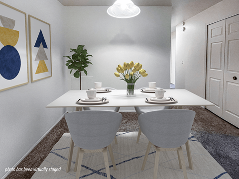 A dining room with a white table and chairs.