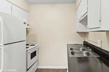 a kitchen with white appliances and a sink and a refrigerator