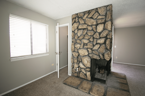 A stone fireplace and living room at Ponderosa Apartments in Wichita, KS