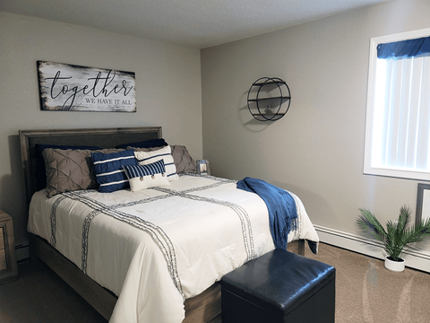 A bedroom with a bed, a bench, and a sign that says "together we have it all".