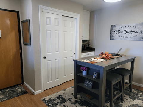 A room with a desk and a framed sign on the wall.