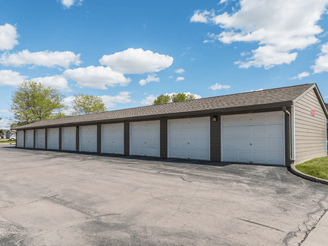 A long building with a grey roof and white garage doors.