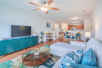 A living room with a white couch and a green cabinet.