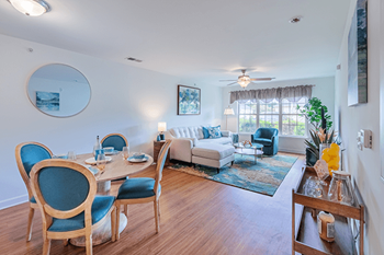A dining room with blue chairs and a white couch.