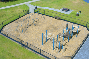 An aerial view of a playground with a basketball hoop, swings, and a slide.