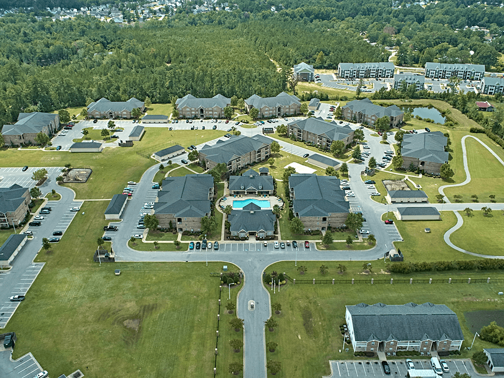A bird's eye view of a residential area with houses and a swimming pool.