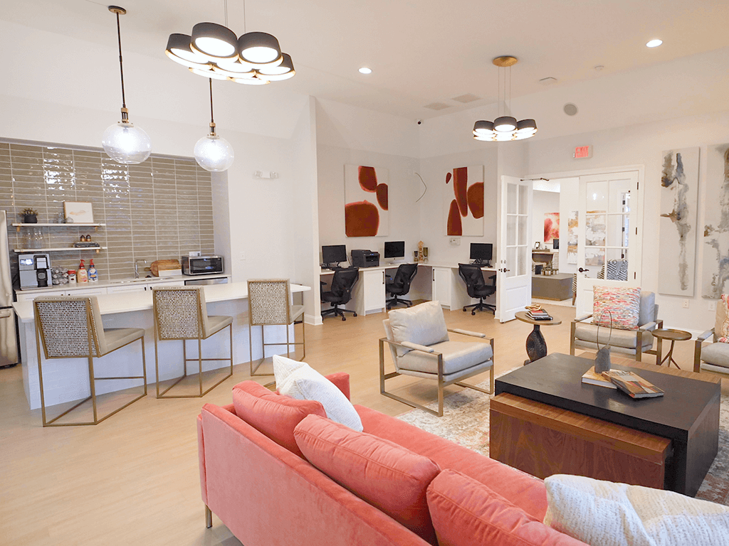 A living room with a red couch and a kitchen area in the background.