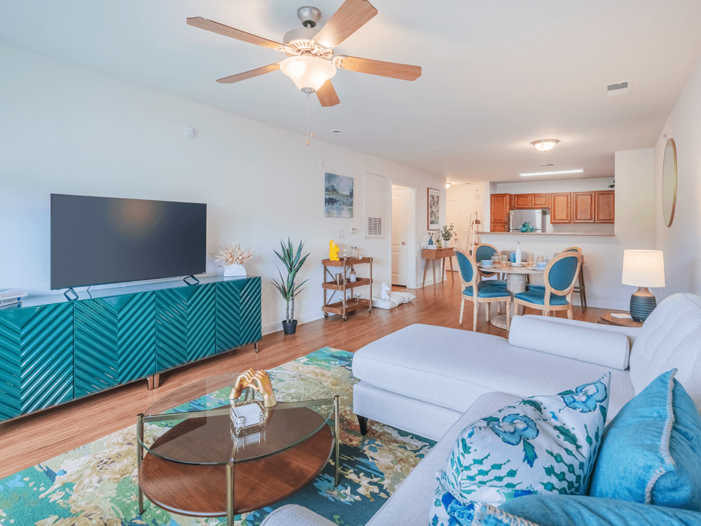 A living room with a white couch and a green patterned cabinet.