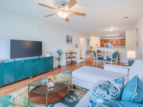 A living room with a white couch and a green patterned cabinet.