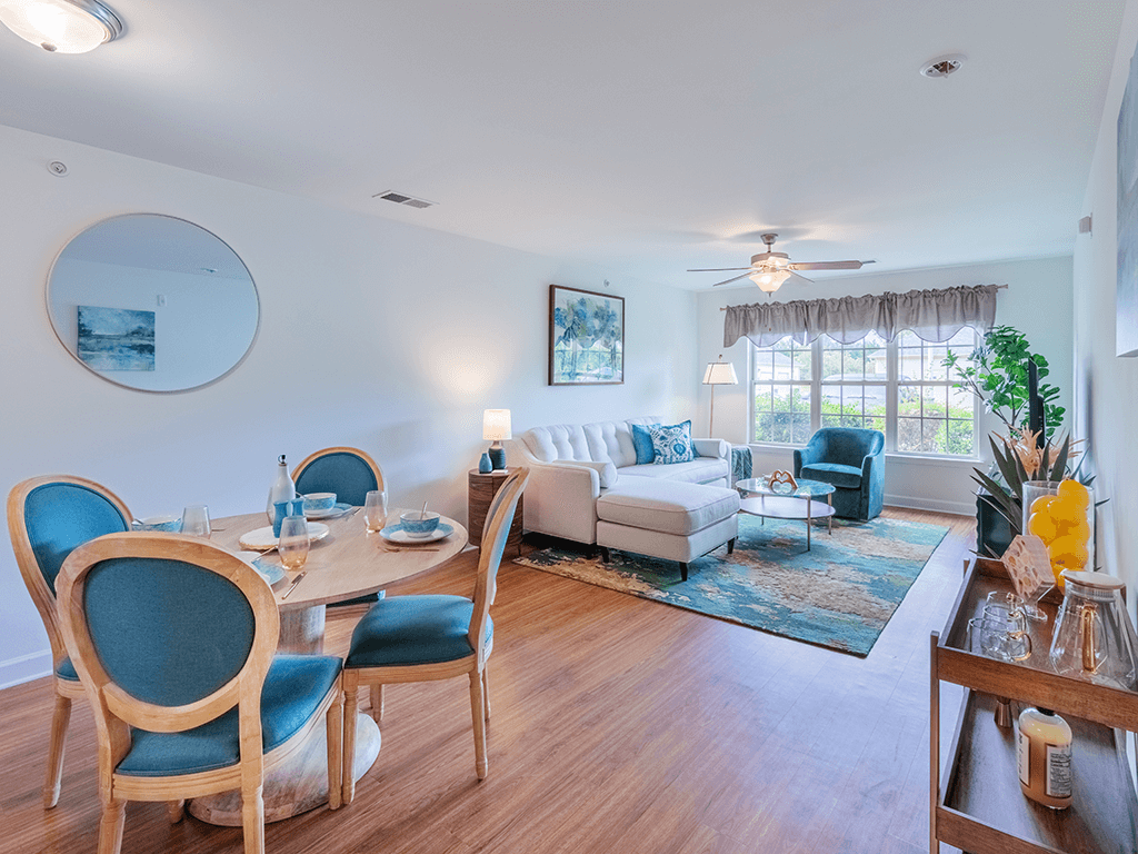 A dining room with blue chairs and a white couch.