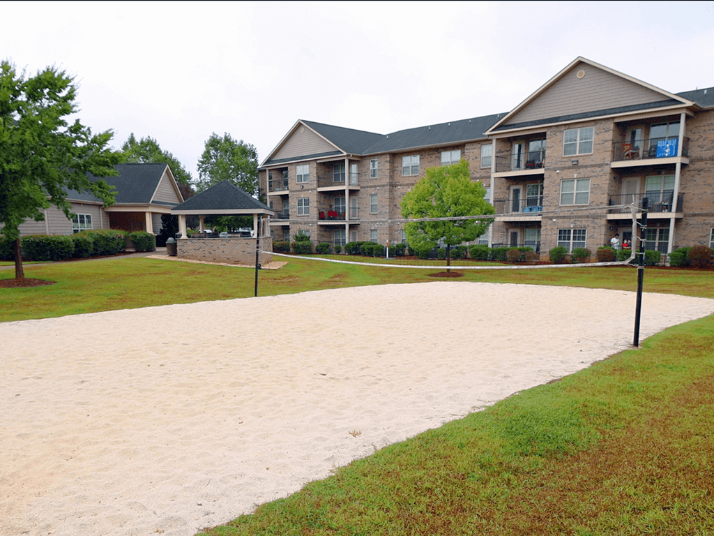 A sandy area in front of apartment buildings.