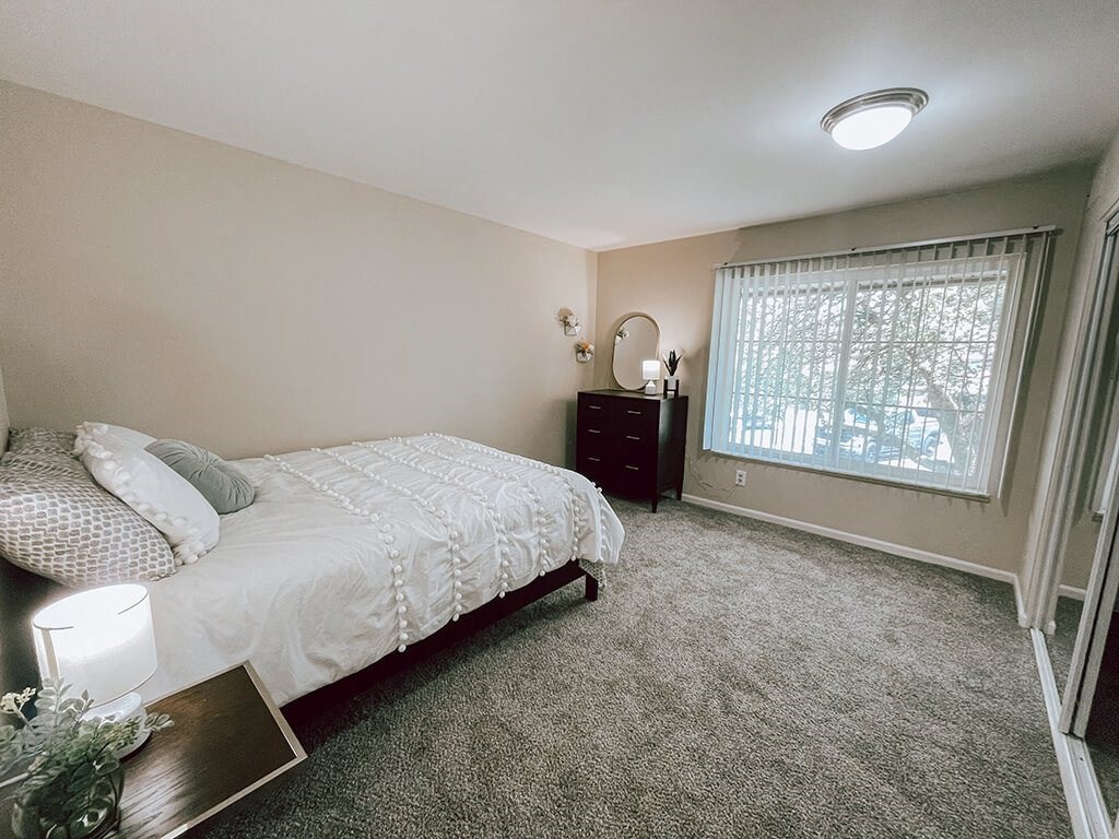 a bedroom with a bed and a window