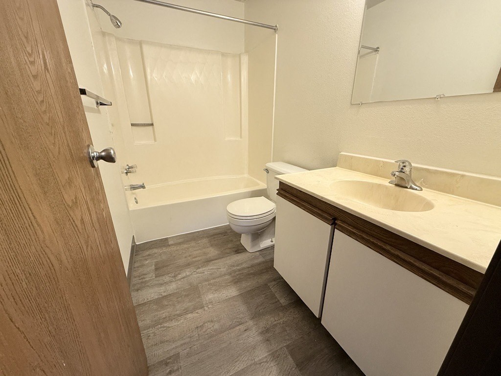 A bathroom with a toilet, sink, and bathtub.