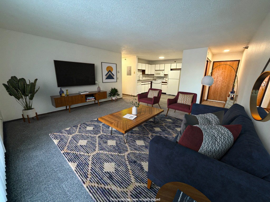 A living room with a dark blue couch and a wooden coffee table.