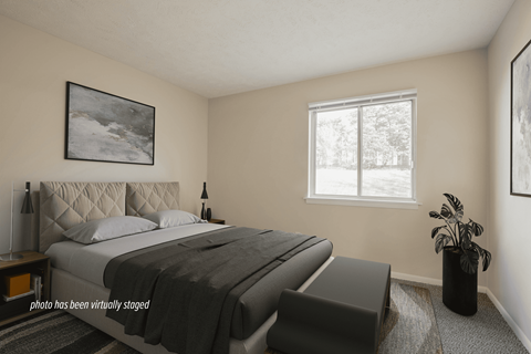 A bedroom with a large bed and a window.