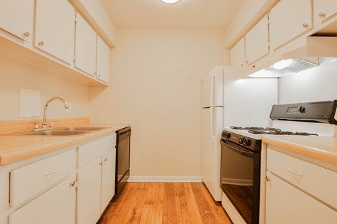 A kitchen with white cabinets and a wooden countertop.
