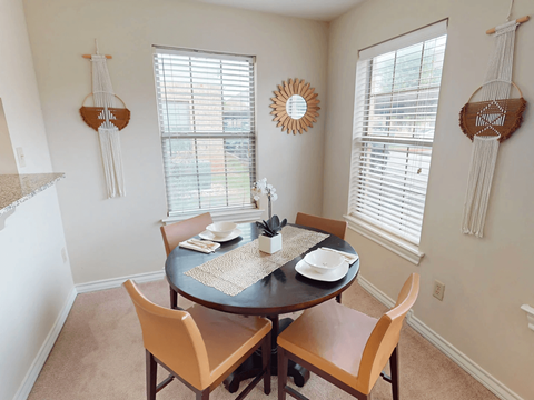 A dining room with a round table and chairs.