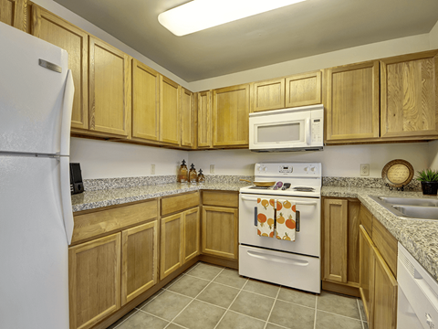 A kitchen with wooden cabinets and a white refrigerator.