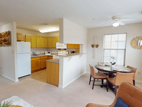 A kitchen with white appliances and wooden cabinets.