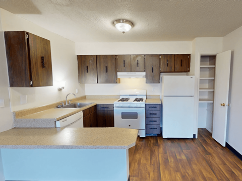 A kitchen with wooden cabinets and a white refrigerator.