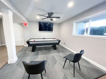 a game room with an air hockey table and a flat screen tv - Photo Gallery 10