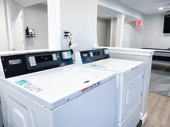 a laundry room with two washers and two dryers - Photo Gallery 12