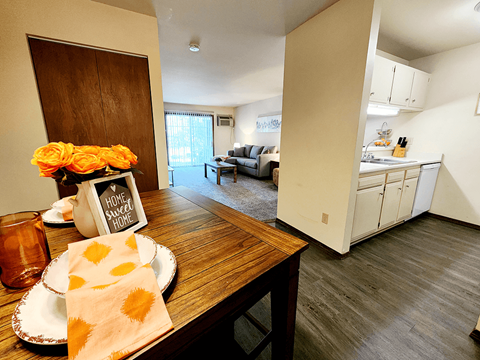 a dining room and living room with a table and a kitchen