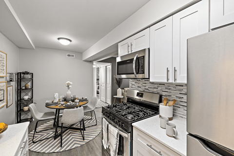 A modern kitchen with a dining table and chairs.