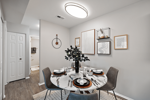 A dining room with a round table set for a meal.