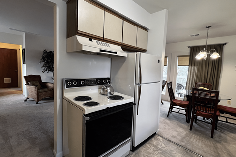 A modern kitchen with a white refrigerator and stove top oven.
