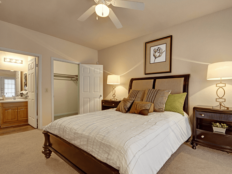 A bedroom with a large bed and a ceiling fan.
