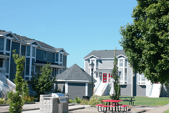 a row of houses with a picnic table in the foreground