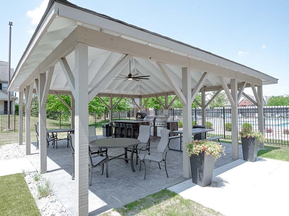 a covered patio with tables and chairs
