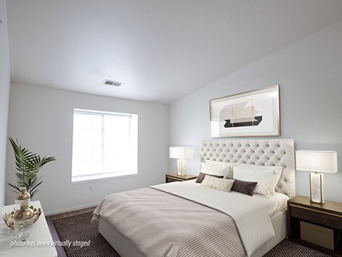 A bedroom with a large bed and a painting above it.