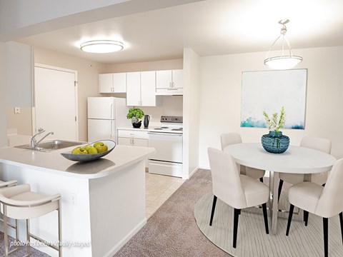 A kitchen with a white counter and a round table with four chairs.