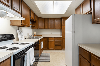 A kitchen with wooden cabinets and a white refrigerator.