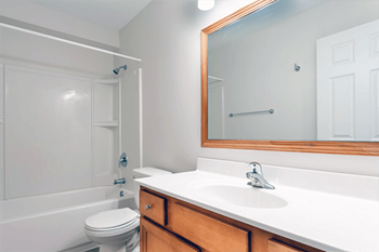 A white bathroom with a toilet, sink, and bathtub.