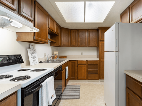 A kitchen with wooden cabinets and a white refrigerator.