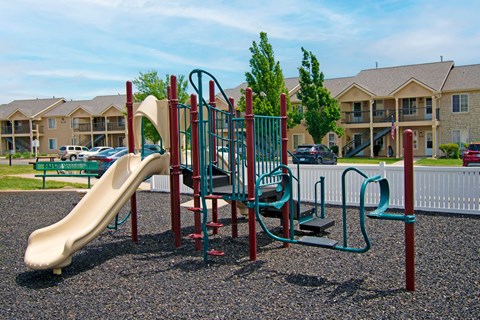 A playground with a slide, swings, and a climbing frame.