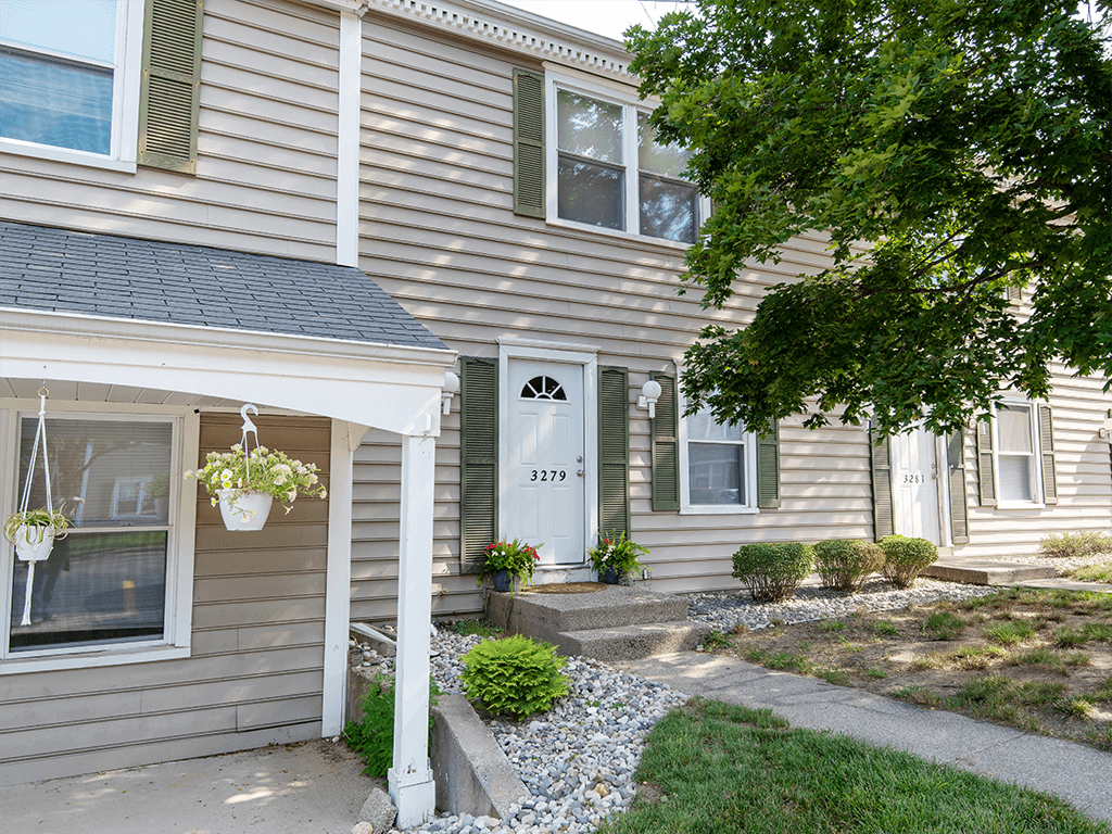 the front of a apartment building with a white door and a porch