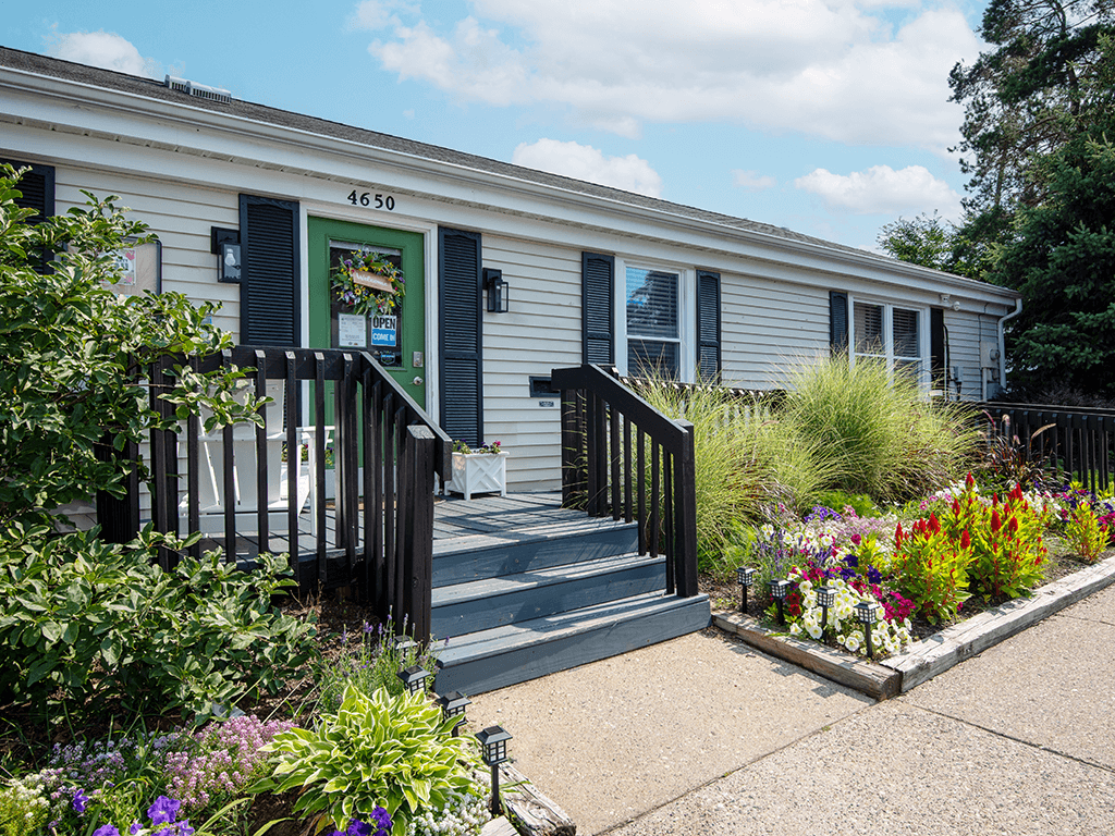 the exterior of rolling pines office with a garden in front of it